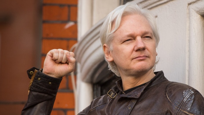 Der Journalist Julian Assange mit erhobener Faust