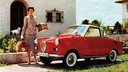 Frau mit Reisetaschen steht neben einem Goggomobil Cabrio