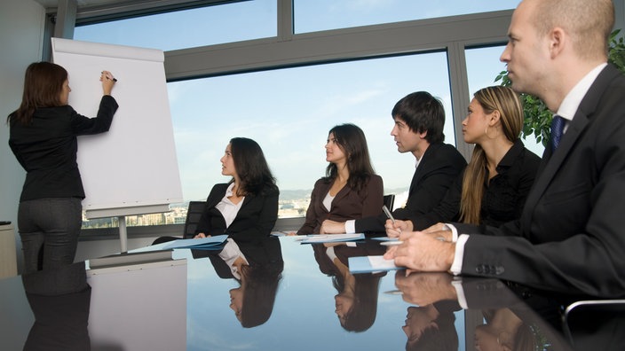 Meeting: Frau steht an Flipchart 