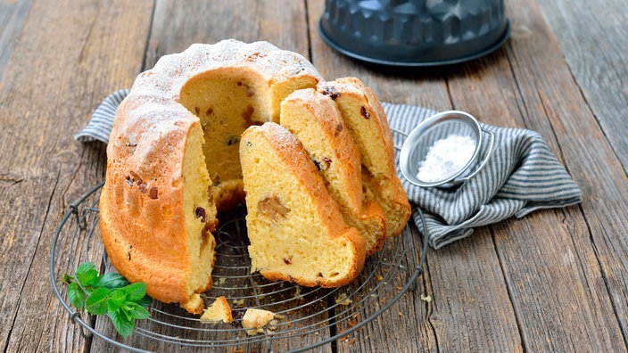 Frischer Hefe-Gugelhupf mit Marzipan und Amaretto-Rosinen auf einem Abkühlring