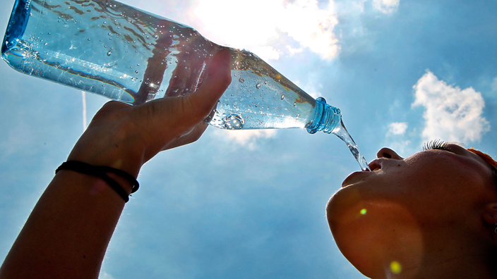 Eine Frau trinkt Wasser.