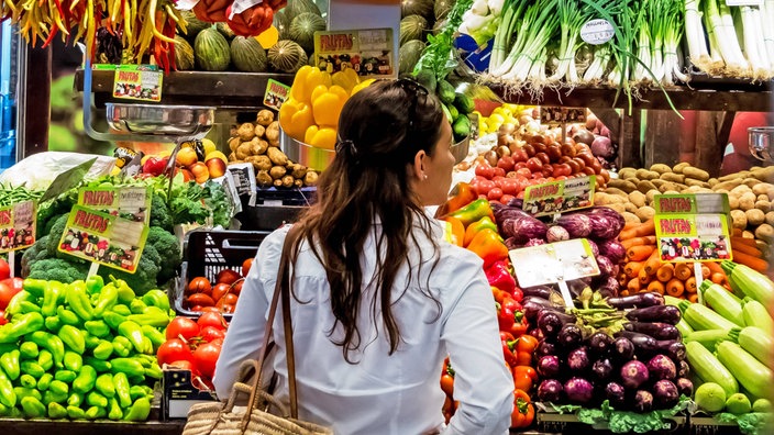 Eine Frau steht vor der Obst- und Gemüsetheke