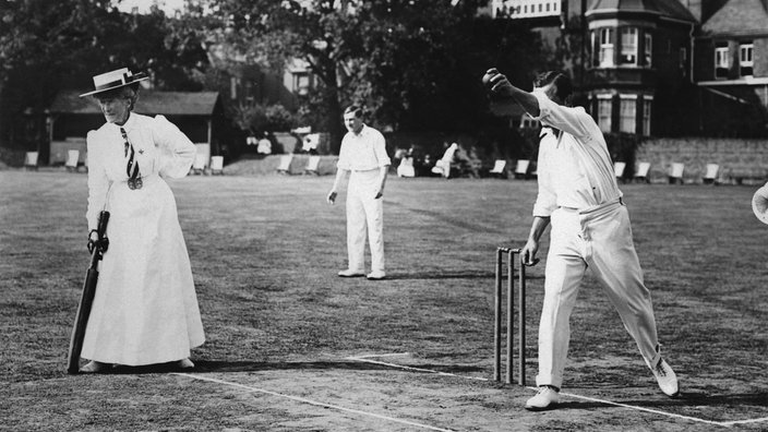 Schwarzweiß-Foto: Mann und Frau beim Kricket-Spiel.