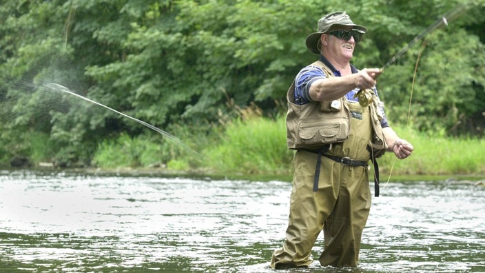 Ein Fliegenangler steht in einem Fluss