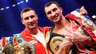 Wladimir und Vitali Klitschko mit Weltmeistergürteln