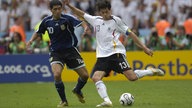 Michael Ballack setzt sich gegen Juan Riquelme aus Argentinien durch und schießt aufs Tor