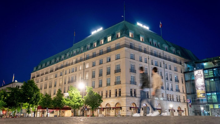 Passanten laufen auf dem Platz vor dem Hotel Adlon Kempinski am Brandenburger Tor