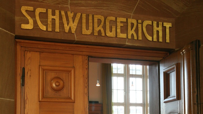 Tür, über der ein Schild "Schwurgericht" hängt