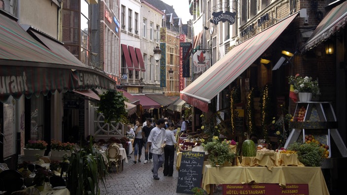 Das Foto zeigt eine enge mittelalterliche Gasse, in der sich ein Restaurant an das andere reiht.