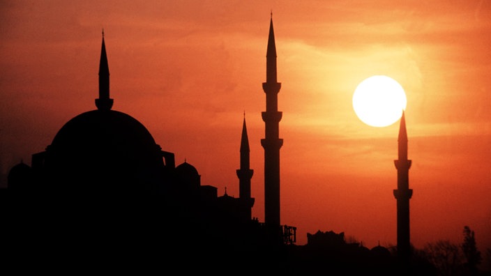 Die Sonne geht hinter den Minaretten der Suleiman-Moschee in Istanbul unter.