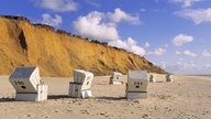 Strandkörbe am Strand von Sylt. Im Hintergrund: das Rote Kliff.