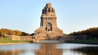 Blick über einen See auf das Völkerschlachtdenkmal in Leipzig.