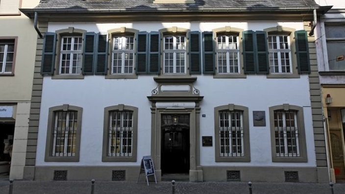 Eingerahmt von zwei moderneren Häusern befindet sich das Geburtshaus von Karl Marx. Das Haus ist weiß gestrichen, das Dach mit Schiefer eingedeckt. In der Fassade ist eine Gedenktafel eingelassen. Vor dem Haus weist eine Klapptafel auf die Sehenswürdigkeit hin. Das Haus besteht aus Erdgeschoss, einem ersten Geschoss und einem Dachgeschoss mit Fenstergauben.