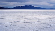 Blick über den Salzsee Salar de Uyuni auf Berge