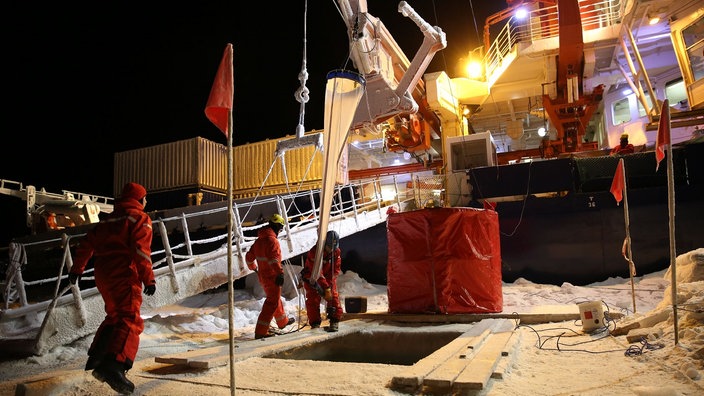 Die Polarstern lässt per Kran ein Netz ins Wasser, um Proben des Lebens unter dem Eis zu sammeln.