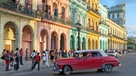 Straßenszene in Havanna: Ein amerikanischer Straßenkreuzer vor alten Häusern.