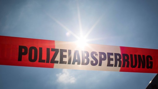 Polizeiabsperrung vor blauem Himmel