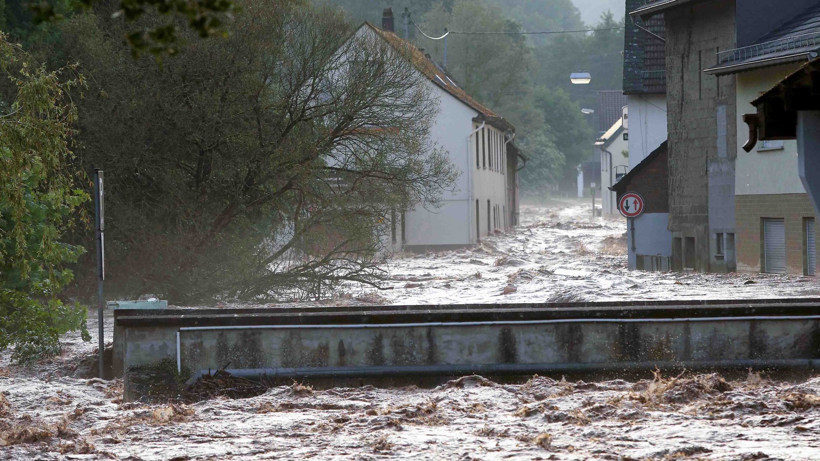 Wassermassen schießen wie ein reißender Fluss durch eine Straße 