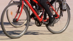 Eine Person fährt auf einem roten Fahrrad.