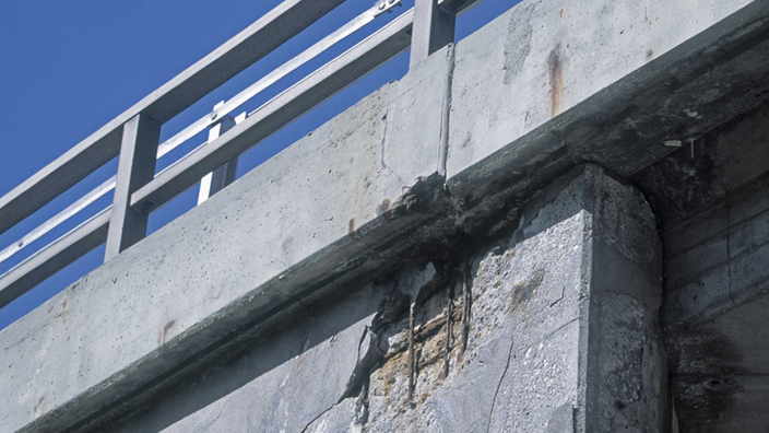 Aufgeplatzter Beton an einer Autobahnbrücke.